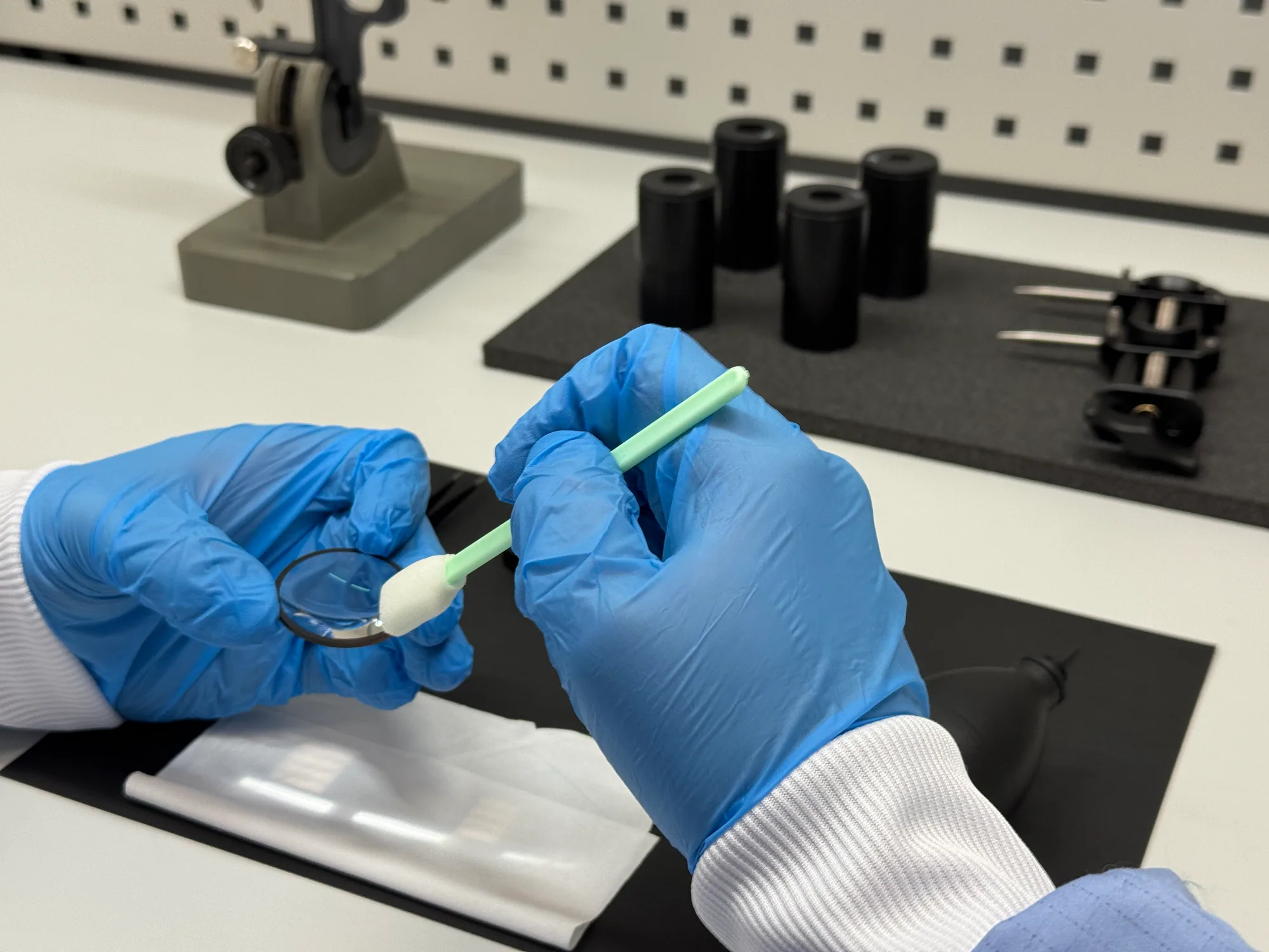 Inspection of an optical lens surface using protective gloves