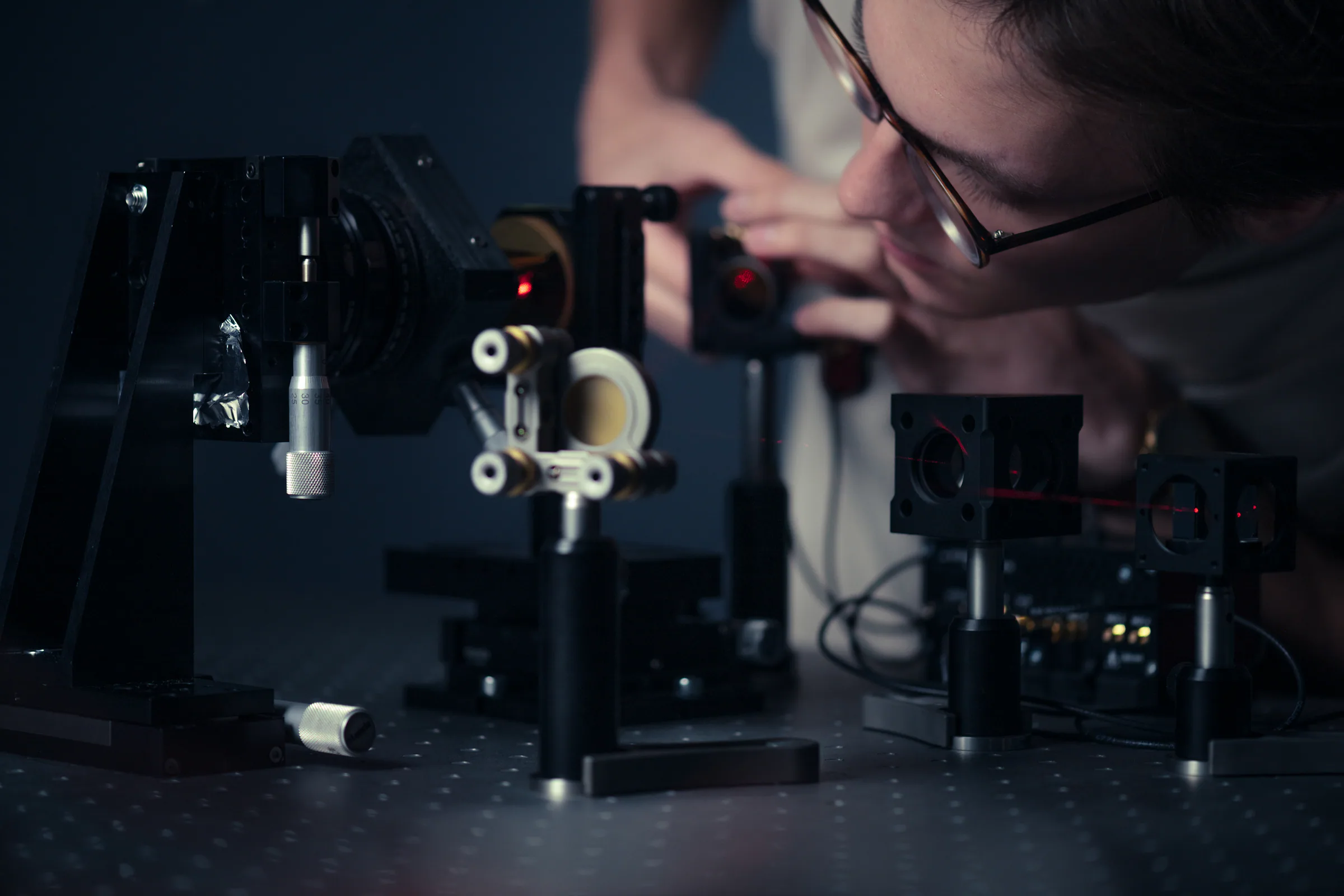 Specialist assembling an optical setup in the laboratory