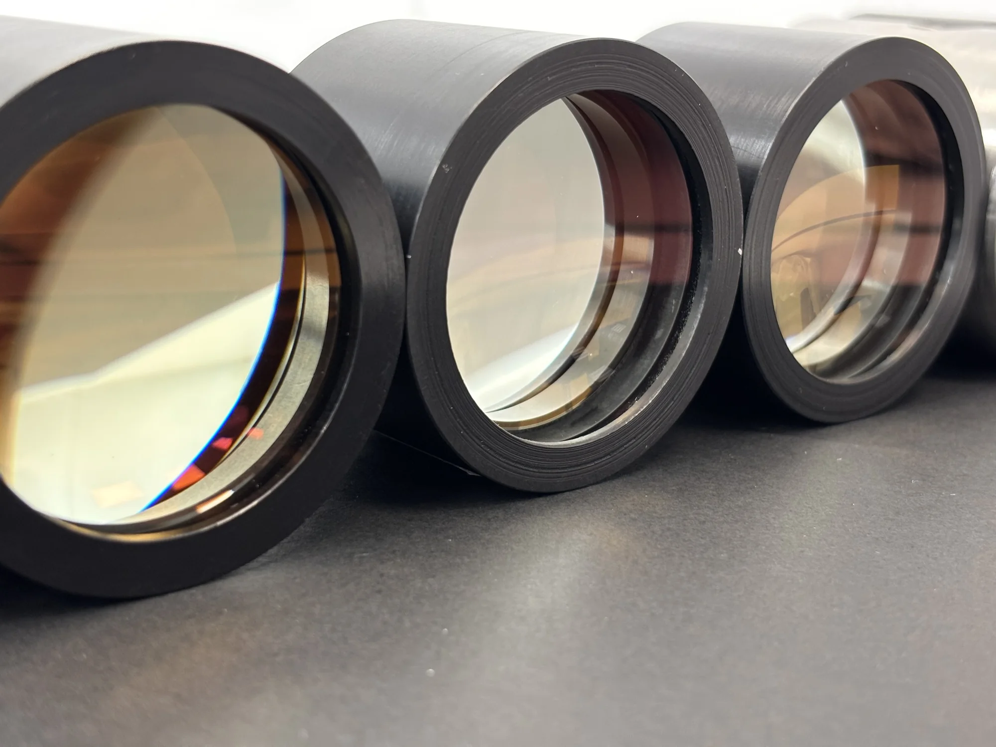 Three optical modules with large lenses in black metal mounts
